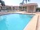 The clear blue swimming pool features an open air cabana and lounge chairs for relaxing at 6507 Stone River Rd # 302, Bradenton, FL 34203