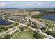 Community aerial view featuring pool, clubhouse, tennis courts and lush landscaping at 6512 Grand Estuary Trl # 101, Bradenton, FL 34212