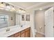 Well-lit bathroom with double vanity and a view into the toilet room at 6512 Grand Estuary Trl # 101, Bradenton, FL 34212