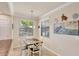 Sunlit breakfast nook features white chairs and a view of the property at 6512 Grand Estuary Trl # 101, Bradenton, FL 34212