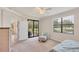 Main bedroom view featuring neutral decor, chair, ottoman, and backyard view at 6512 Grand Estuary Trl # 101, Bradenton, FL 34212