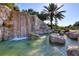 Beautiful rock waterfall feature with River Strand signage and lush tropical plants at 6512 Grand Estuary Trl # 101, Bradenton, FL 34212