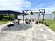 Charming backyard patio features a pergola, grill, chairs and blooming potted plants at 8509 La Boca Ave, North Port, FL 34287