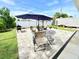 Relaxing backyard patio features a large umbrella, chairs, grill and privacy fence at 8509 La Boca Ave, North Port, FL 34287