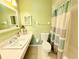 Charming bathroom features a tile floor, sink, toilet and shower with neutral green paint at 8509 La Boca Ave, North Port, FL 34287
