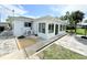 Rear exterior of the home shows sunroom addition, paved patio and backyard at 8509 La Boca Ave, North Port, FL 34287