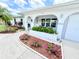 Inviting home exterior featuring an arched entryway, decorative flower beds, and meticulously maintained landscaping at 8509 La Boca Ave, North Port, FL 34287