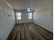 Bright bedroom featuring wood-look floors, white walls, and contemporary chandelier at 931 Signet Dr, Apollo Beach, FL 33572