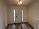 Bright foyer featuring a white door with sidelights, wood-look floors, and a modern light fixture at 931 Signet Dr, Apollo Beach, FL 33572