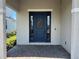 Inviting front entrance with a navy door, sidelights and a decorative wreath at 931 Signet Dr, Apollo Beach, FL 33572