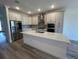 Modern kitchen with white cabinets, stainless steel appliances, and a quartz countertop island at 931 Signet Dr, Apollo Beach, FL 33572