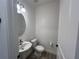 Stylish powder room with a pedestal sink, modern faucet, and a round mirror at 931 Signet Dr, Apollo Beach, FL 33572