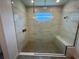 Glass enclosed shower with marble look tiles, mosaic floors, and bench seating at 931 Signet Dr, Apollo Beach, FL 33572