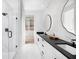 Modern bathroom featuring marble walls, black hardware, and a walk-in closet at 9990 Key Haven Rd, Seminole, FL 33777