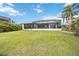 Spacious backyard featuring a well-maintained lawn, screened patio, and waterfront access, great for outdoor enjoyment at 103 Graham Se St, Port Charlotte, FL 33952