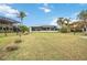 Lush backyard with a large lawn and mature trees, leading to serene waterfront views at 103 Graham Se St, Port Charlotte, FL 33952