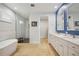 Bright bathroom featuring double vanity sinks, a soaking tub and a walk-in shower at 103 Graham Se St, Port Charlotte, FL 33952