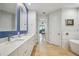 Modern bathroom featuring double vanity sinks, a soaking tub and view into the Primary bedroom at 103 Graham Se St, Port Charlotte, FL 33952