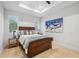 Bright bedroom with tray ceiling, windows with shutters, and a dark wood bed with neutral bedding at 103 Graham Se St, Port Charlotte, FL 33952