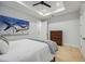 Bright bedroom with tray ceiling, windows with shutters, and a dark wood bed with neutral bedding at 103 Graham Se St, Port Charlotte, FL 33952