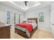 Bright bedroom with tray ceiling, windows with shutters, and a cozy bed with red and blue bedding at 103 Graham Se St, Port Charlotte, FL 33952