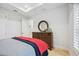 Bright bedroom with tray ceiling, dresser with round mirror, and a cozy bed with red and blue bedding at 103 Graham Se St, Port Charlotte, FL 33952