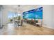 Dining area with outdoor access and a large coastal artwork above a serving bar and a modern chandelier at 103 Graham Se St, Port Charlotte, FL 33952
