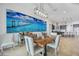 Well-lit dining room with a large wooden table, coastal-themed artwork, and stainless steel light fixture at 103 Graham Se St, Port Charlotte, FL 33952