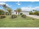 A beautiful home with a three car garage and paver driveway is surrounded by lush landscaping at 103 Graham Se St, Port Charlotte, FL 33952