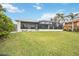 Exterior view of home, showcasing the screened patio, manicured lawn, and waterfront location at 103 Graham Se St, Port Charlotte, FL 33952