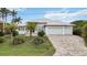Striking home exterior with three-car garage, well-manicured landscaping, and a circular driveway at 103 Graham Se St, Port Charlotte, FL 33952