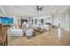 Expansive living room featuring neutral furnishings, ceiling fan, and travertine tile flooring, perfect for entertaining at 103 Graham Se St, Port Charlotte, FL 33952