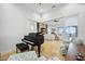 Open-concept living area with a piano, travertine floors, and seamless indoor-outdoor transition to the patio at 103 Graham Se St, Port Charlotte, FL 33952