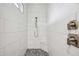 Modern walk-in shower with white subway tile, mosaic tile floor, a built-in seat, and sleek fixtures for a spa-like feel at 103 Graham Se St, Port Charlotte, FL 33952