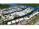 Aerial of a waterfront neighborhood featuring tennis courts, a community pool, and individual boat docks at 10311 Waterbird Way, Bradenton, FL 34209