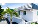 Inviting two-story coastal home with a white exterior, stairs leading to the upper entrance, and a palm tree at 10311 Waterbird Way, Bradenton, FL 34209