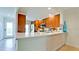 Modern kitchen with stainless steel appliances, white countertop, brown cabinetry, and adjacent to the dining room at 10311 Waterbird Way, Bradenton, FL 34209