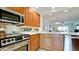 Bright kitchen with stainless steel appliances and view into the living room at 10311 Waterbird Way, Bradenton, FL 34209