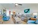 Comfortable living room with tile flooring, sofa, recliners, and open access to the kitchen and dining area at 10311 Waterbird Way, Bradenton, FL 34209