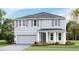 Charming two-story home showcasing a neutral palette, gray shutters, and a well-manicured lawn at 17936 Tavernside Trl, Lakewood Ranch, FL 34211