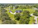 This aerial shot showcases a beautiful property with a large yard, detached garage, and mature trees, offering space and privacy at 18307 White Fang Ct, Parrish, FL 34219
