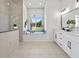 Bright bathroom with a soaking tub, glass enclosed shower, and dual sink vanity at 18307 White Fang Ct, Parrish, FL 34219
