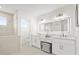 Modern bathroom featuring a double sink vanity, large mirror, and a shower at 18307 White Fang Ct, Parrish, FL 34219