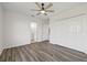 Spacious bedroom with wood-look floors, ceiling fan, and access to the ensuite bathroom at 18307 White Fang Ct, Parrish, FL 34219