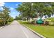 Community entrance with lush landscaping and a stone sign; a serene street view lined with manicured lawns and trees at 18307 White Fang Ct, Parrish, FL 34219