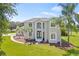 Beautiful two-story home featuring a landscaped yard with mature palm trees and a circular driveway at 18307 White Fang Ct, Parrish, FL 34219