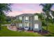 Beautiful two-story home featuring a landscaped yard with mature palm trees and a circular driveway at dusk at 18307 White Fang Ct, Parrish, FL 34219