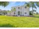Stunning two-story home boasting lush landscaping, mature palms, and a well-manicured lawn on a sunny day at 18307 White Fang Ct, Parrish, FL 34219