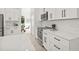 Well-lit kitchen with modern appliances, white cabinets, and quartz countertops with a view of the dining area at 18307 White Fang Ct, Parrish, FL 34219