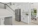 Bright kitchen featuring stainless steel appliances and white cabinets adjacent to a staircase and dining area at 18307 White Fang Ct, Parrish, FL 34219